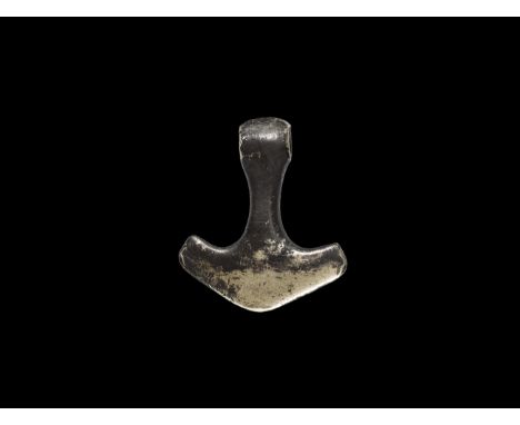 9th-11th century AD. A silver Thor's Hammer pendant (Mjolnir) with round-section shank, broad pentagonal head, bulb finial wi