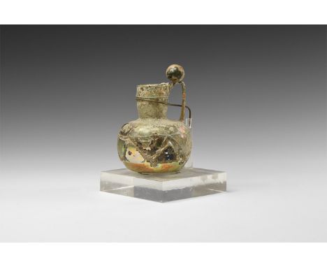 4th-6th century AD. A mould-blown iridescent glass vessel with drum-shaped body and tubular neck, rolled rim, bands of fine a
