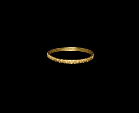 14th-15th century AD. A gold finger ring comprising a flat-section hoop with decoration of opposed notches.  0.73 grams, 17mm