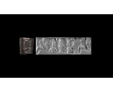 20th-19th century BC. A haematite cylinder seal fragment with figures and cuneiform text; accompanied by an old scholarly not