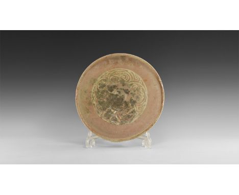 12th century AD. A large ceramic bowl with glazed decoration to the inside consisting of a scrolling plant motif in a band, l