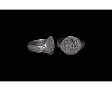 8th-10th century AD. A silver D-section ring enclosing a flat discoid bezel with personal monogram.  6.39 grams, 19.73mm over