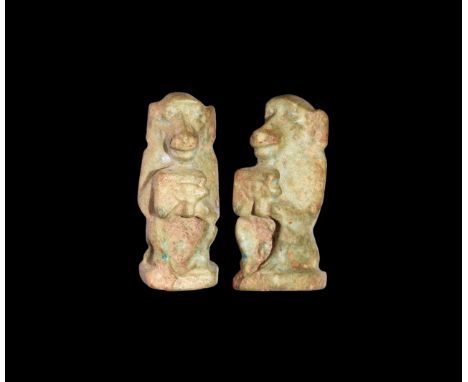 Third Intermediate Period, 1069-702 BC. An olive green glazed composition amulet of Thoth in baboon form, crouching and holdi