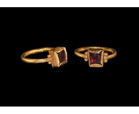 5th-6th century AD. A gold finger ring comprising a round-section hoop and square bezel with granules to each shoulder, inset