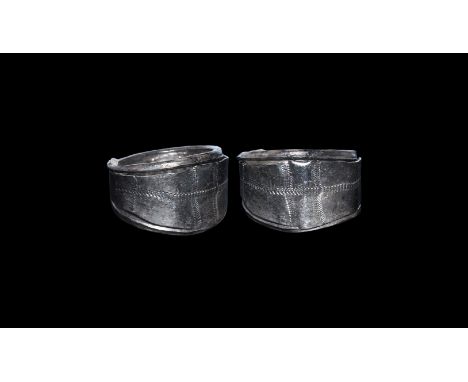 10th-12th century AD. A sheet silver finger ring with median hoop extending to two round-section bars coiled to the edges of 