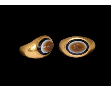 2nd-4th century AD. A gold finger ring comprising a C-section hoop with flared shoulders, plaque with inset banded agate gem,