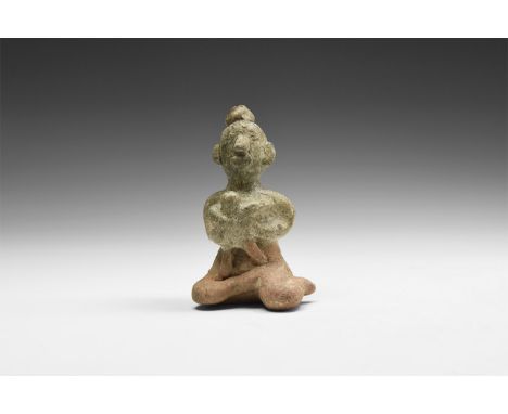 14th-16th century AD. A green-glazed ceramic figurine of a nude seated female suckling a baby in her arms; hollow to the unde