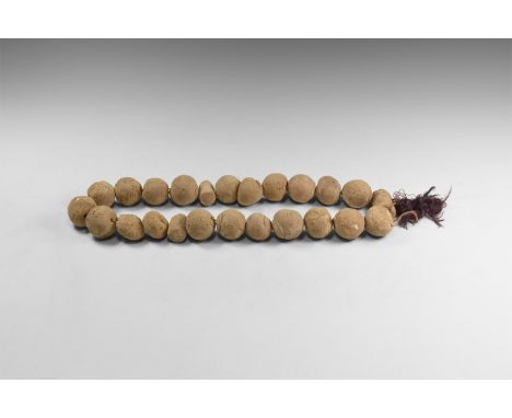 19th century AD. A restrung group of ceramic spherical and columnar weights, some with incised linear ornament.  1 kg, 32-45m