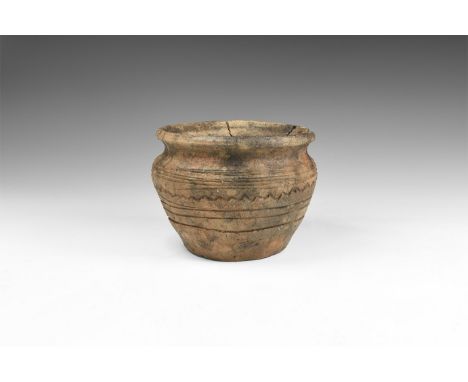 2nd millennium BC. A ceramic jar with bulbous body, narrow shoulder and everted chamfered rim, bands of horizontal lines to t