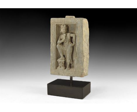 2nd century AD. A rectangular panel with niche to the front with standing figure of Maitreya wearing a turban, head turned to