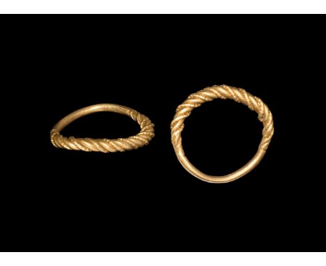 9th-11th century AD. A gold finger ring with tapering shank, band of alternating plain and beaded wires twisted about each ot