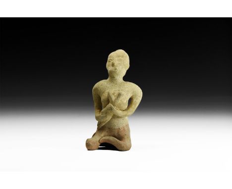 12th-16th century AD. A green-glazed ceramic figurine of a nude seated female suckling a baby in her arms; hollow to the unde