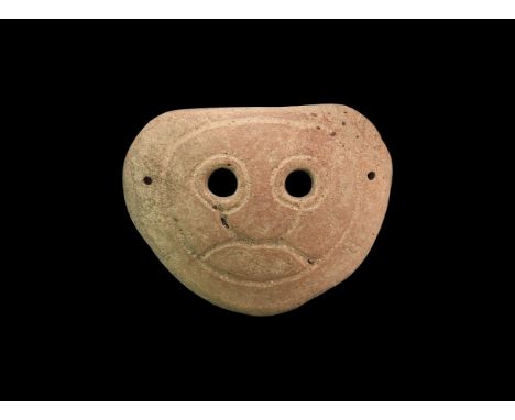 4th-3rd century BC. A slightly domed ceramic funerary(?) mask with two eye-holes and incised facial detailing; attachment hol