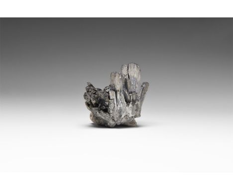 . A specimen of stibnite with striated and bladed silvery crystals in radiate association with a white crystalline calcite ma