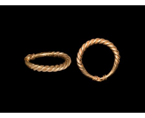 9th-11th century AD. A round-section gold hoop formed from twisted rods, the ends coiled around the shank.  6.72 grams, 24.39