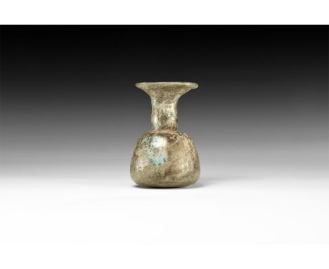 3rd-4th century AD. A mould-blown glass vessel comprising a flat-based bulbous body and bell-shaped neck with applied rim. Se