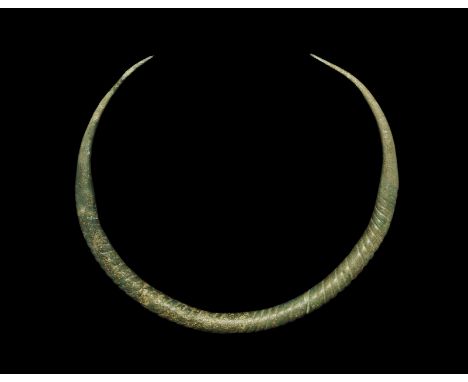 10th-11th century AD. A penannular neck-ring with tapering terminals and expanded central portion decorated with moulded spir