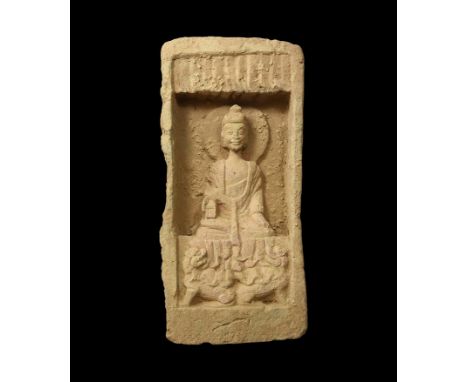 Northern Wei Dynasty, 386-534 AD. A rectangular grey ceramic brick with recess to the upper face enclosing a robed Buddha fig