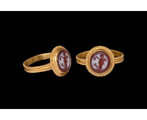 3rd-4th century AD. A gold finger ring with median beaded wire band to the hoop, discoid bezel with beaded wire border, carne