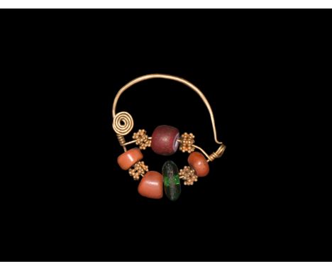 18th century AD. A gold nose-ring with wire hoop with two bars threaded with red abd green glass beads, three coral beads abd