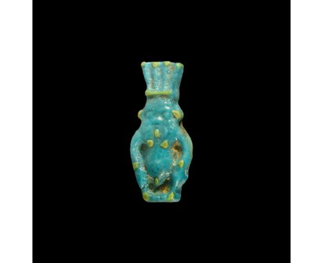 Late Period, 664-332 BC. A blue glazed composition amulet of Bes with feathered headdress, applied yellow spot detailing. Cf.