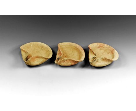 2nd-1st millennium BC. A group of three ceramic oil lamps, each a disc with edges folded to form a triangular dish and nozzle