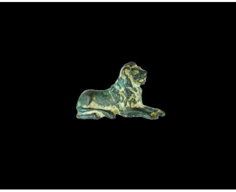 1st-3rd century AD. A bronze figure of a reclining lion with detailing of fur to the mane; forepaws extended.  17 grams, 30mm