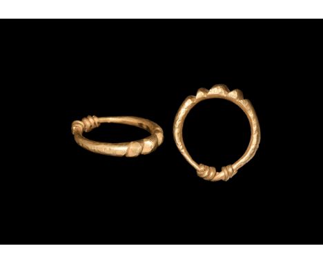 9th-11th century AD. A gold finger ring formed as a round-section rod with the ends coiled about the shank, notches to the up