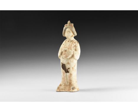 Tang Dynasty, 618-907 AD. A ceramic figure of a courtly lady in draped robe with neatly dressed hair, hands to chest holding 