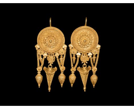 4th century BC. A pair of gold earrings with central shield decorated with bead wire to the edges; within each shield a serie