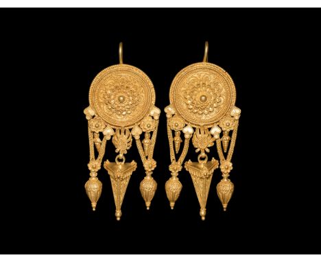 4th century BC. A pair of gold earrings with central shield decorated with bead wire to the edges; within each shield a serie