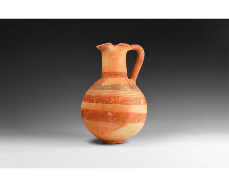 Iron Age, 10th-6th century BC. A terracotta globular jug with basal ring, broad tubular neck with pinched sides and pouring l