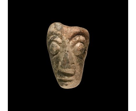 Pleistocene Period, 2.6 million-11,700 years BP. A carved mammoth bone face with bulbous eyes and triangular nose.  74 grams,