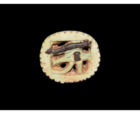 Third Intermediate Period, 1069-702 BC. A pale green glazed composition discoid amulet with dentilled border, openwork wedjat