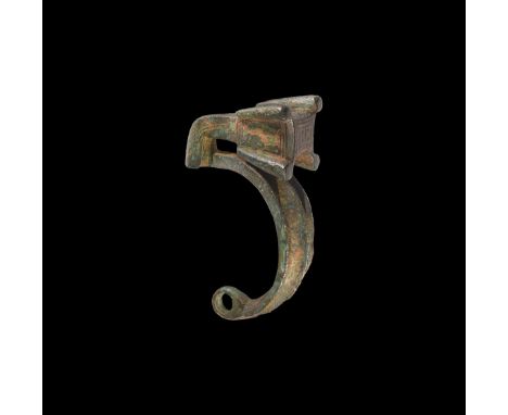 6th-3rd century BC. A cast bow brooch comprising a loop finial and arched bow with fluted flanges, L-shaped footplate with ca