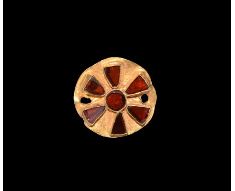 5th-6th century AD. A sheet gold disc with repoussé cells, a central roundel and radiating triangles each with an inset garne