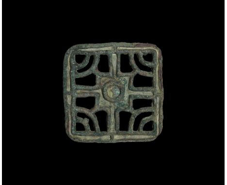 7th-10th century AD. A bronze bread stamp, square with loop handle, openwork design with central cross and concentric arcs.  