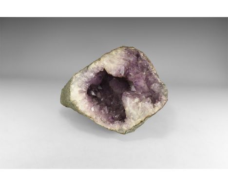 . A large amethyst geode, with large crystals to the front of the opening creating a large, crystal-lined hollow within. See 