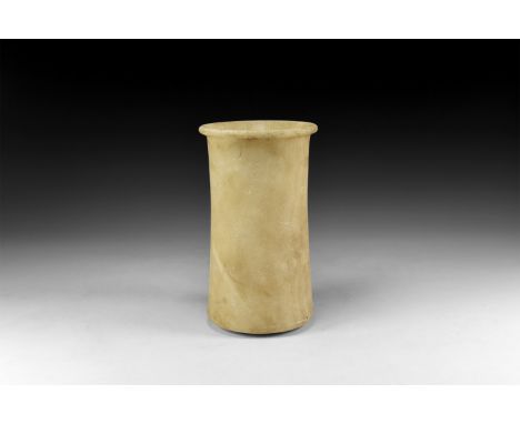 2nd millennium BC. An alabaster vase with slightly flared and rolled rim; thick walls to the tapering body, slightly rounded 