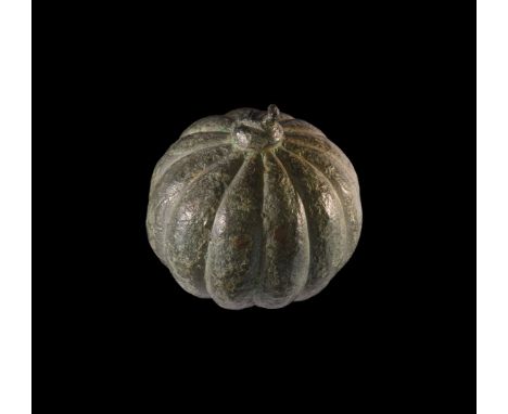 1st-2nd century AD. A bronze weight in the form of an orb with segmented sides, to the bottom a dished recess, remains of loo