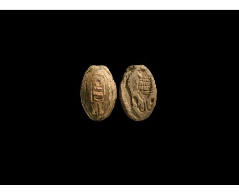 Third Intermediate Period, 1069-702 BC. A grey ceramic plano-convex scaraboid amulet with intaglio fish to the underside, hie