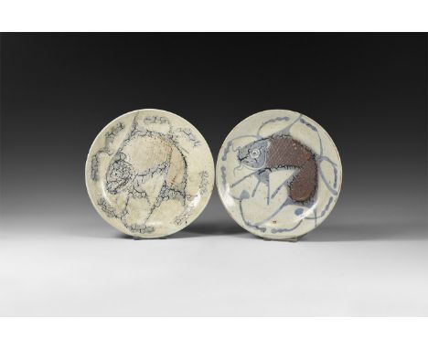 Ming Dynasty, 1368-1644 AD. A pair of glazed ceramic dishes each with a blue glazed fish motif among strands, textured body. 
