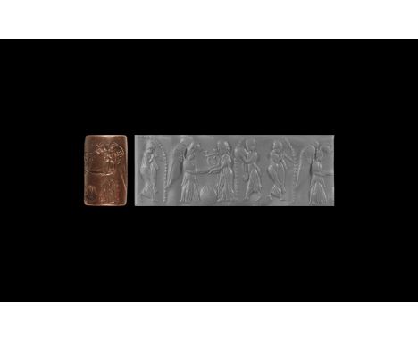 4th-1st century BC. A carved haematite (?) stone cylinder seal with central motif of a standing winged figure facing a robed 