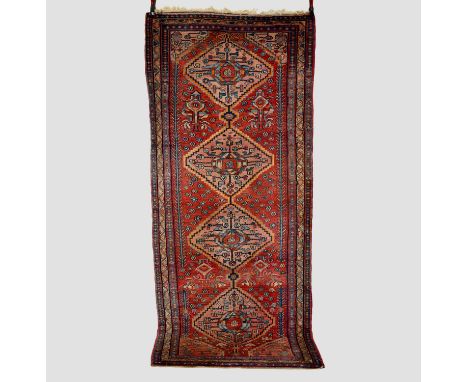 Kurdish runner, north west Persia, mid-20th century, 9ft. 10in. X 4ft. 2in. 3m. X 1.27m. Light red field with pale pink centr