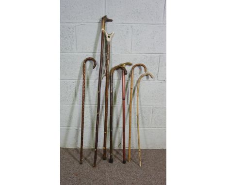 Seven assorted walking sticks and canes, including a thumb stick, brass topped cane and antler headed stick (7)