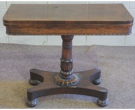 A George IV rosewood card table, circa 1825, with a rotating rounded fold-over top, opening to reveal a baize lined surface a