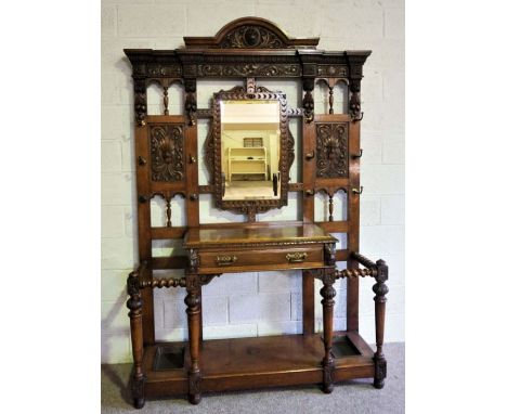 A large Victorian oak Jacobean hall stand, signed Maple &amp; Co., the back with a central mirror flanked by carved 'Green Ma