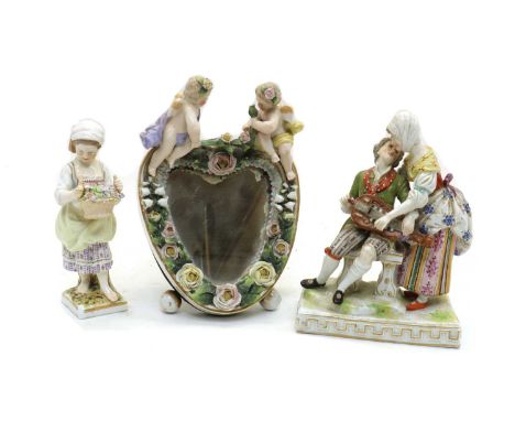 A Dresden porcelain figure group of a hurdy-gurdy player and lady,c.1900, on a Greek key gilt decorated base,12.5cm wide17.5c