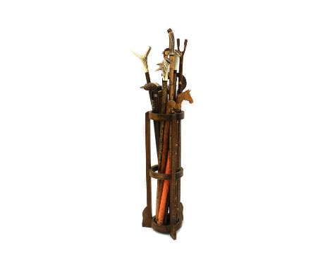 An oak stick stand containing eighteen various modern walking sticks,some with carved horn handles,longest 118cmCondition rep