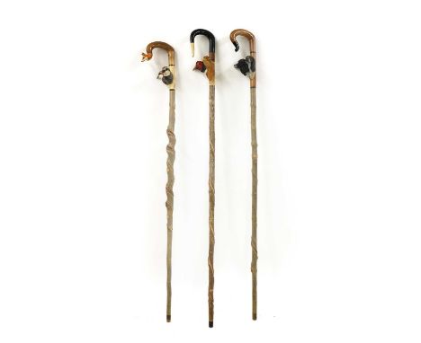 A group of three carved walking sticks by Sam Wright of Norfolk,of recent manufacture, the first with two partridge and foxes